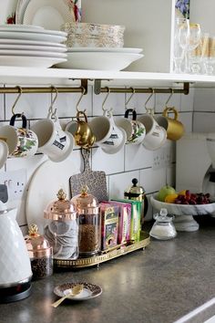 the kitchen counter is clean and ready to be used for teas, coffee cups, and other things