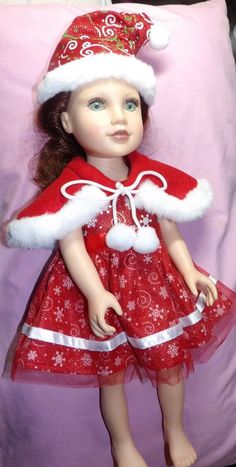 the doll is wearing a santa hat and red dress