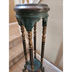 an old wooden table sitting on top of a carpeted floor next to a stair case