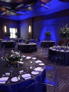 a banquet room with round tables and blue lighting