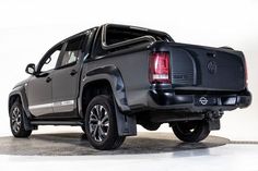 the back end of a black truck on a white background with no people around it