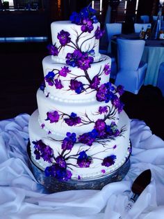 a wedding cake with purple flowers on it