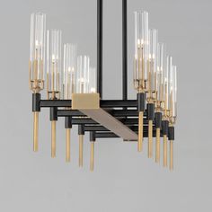 a chandelier with many lights hanging from it's sides and gold bars on each end