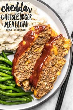 a plate with meatloaf, green beans and mashed potatoes on the side