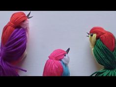 three different colored birds sitting next to each other on top of a white countertop