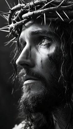 a black and white photo of jesus wearing a crown of thorns on his head