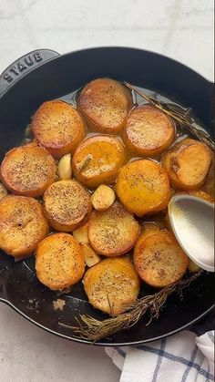 some food is cooking in a skillet on the table with a napkin and spoon