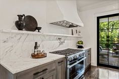 a kitchen with marble counter tops and stainless steel appliances in the middle of the room