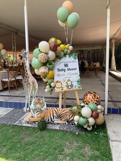 a baby shower sign surrounded by balloons and giraffes