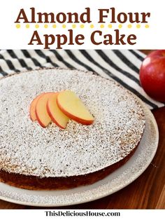 an apple cake with powdered sugar on top and sliced apples in the background text reads, almond flour apple cake