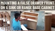 a man in blue shirt working on an unfinished cabinet with text overlay saying mounting a false drawer front on a sink or range base cabinet