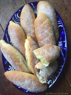 a blue plate topped with pastries covered in powdered sugar