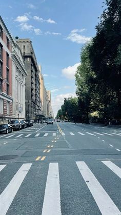 an empty city street with cars parked on both sides