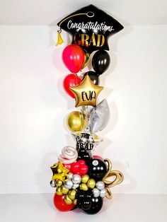 a graduation balloon tower with balloons and confetti