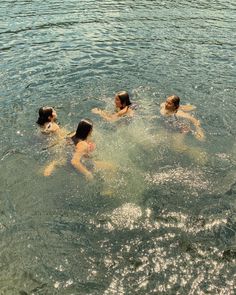 four people are swimming in the water together