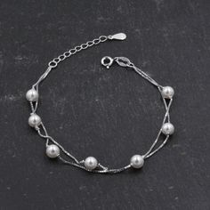 Sterling Silver Beautiful Pearl Minimalist Charm Layer Bracelet - Adjustable Length - Simple and Elegant Jewellery  Dimensions: the pearls measure approx 5mm. Chain Length: 17 cm plus 3cm, suitable for most wrist sizes including children's wrists.  ♥ All our jewellery comes with our branded velvet bag so your item is ready to be gifted. ♥ ★Free Shipping for UK orders, a flat postage fee applies to rest of world. All our items are ready to ship within 48 hours. One postage fee charged per order. Minimalist Silver Pearl Bracelet With Adjustable Chain, Elegant Silver Chain Bracelet With Round Beads, Minimalist Silver Pearl Chain Bracelet, Silver Pearl Bracelets With Adjustable Chain, Silver Pearl Bracelet With Adjustable Chain, Elegant Jewellery, Circle Bracelet, Dog Earrings, Buy Earrings