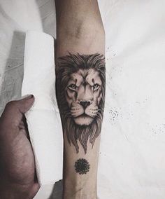 a man's arm with a lion tattoo on it and a flower in the middle