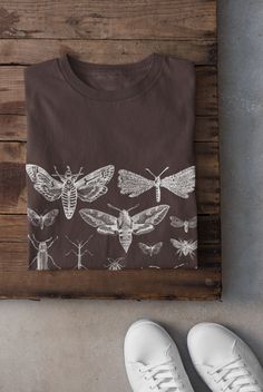 Thanks for stopping by! Moths and Bugs T-shirt Printed on a super soft, cotton tee Dispatched in 5 working days or sooner Unisex Free UK delivery Material: 100% ringspun cotton. Chest (to fit): S  34/36   M  38   L  40/42   XL  44/46   XXL  48/50 ECO-FRIENDLY Each garment is made to order, reducing extra material and energy that would be otherwise wasted We use DTG printing process which is easier on the environment than screen-printing Our ink is bright and also eco-friendly. Do not tumble dry Fairycore Shirt, Climbing Gifts, Black Balloon, Dark Academia Clothing, Trad Goth, Grunge Clothing, Grunge Fairycore, Cottagecore Shirt, Shirt Company