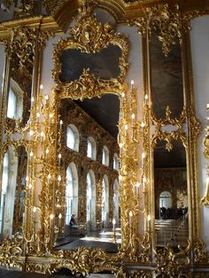 an ornately decorated wall with mirrors and chandeliers in the middle of it