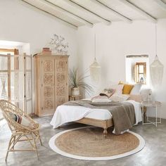 a bedroom with white walls and wooden furniture