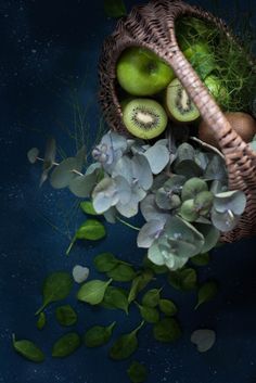 an arrangement of fruits and vegetables in a wicker basket