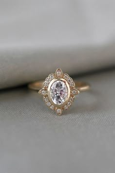 a diamond ring sitting on top of a white cloth