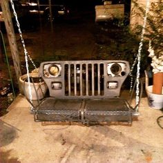 an old jeep front end swing is being used as a porch swing for the garden