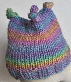 a knitted hat with two pompoms on top