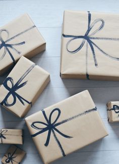 four wrapped presents sitting on top of each other with blue ribbons and bows around them