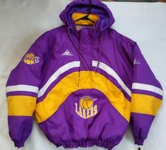 a purple and yellow jacket with the los angeles lakers on it sitting on a table