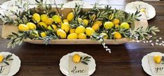 the table is set with lemons and greenery for an elegant centerpiece that says, i do y'all