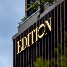 a building with a sign that reads editor on it's side and trees in the foreground