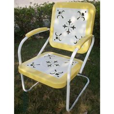 a yellow and white chair sitting in the grass