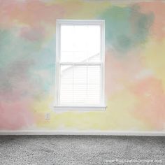 an empty room painted in pastel colors with a window on the far wall and carpeted floor