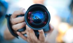 a person holding up a camera lens to take a photo with it's reflection