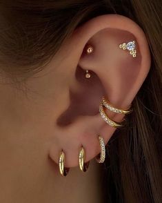 a woman's ear with three different types of piercings