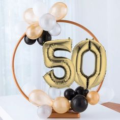 a 50th birthday decoration with balloons in the shape of an o and number 50 on a table