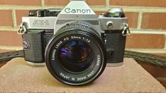 a camera sitting on top of a table next to a brick wall