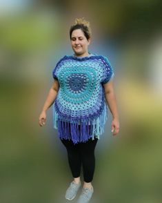 a woman wearing a crocheted blue and purple ponchy