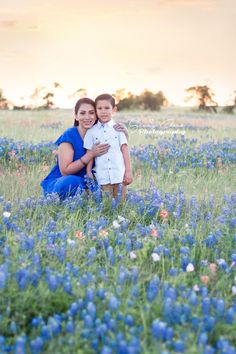 a mother and son pose for a photo in a field of blue bonnets at sunset