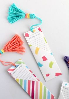 some tassels are laying next to each other on a white surface with colorful tags