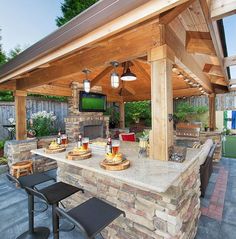 an outdoor kitchen with stone counter tops and grilling area