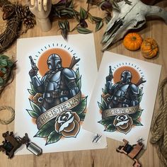 two star wars themed posters on top of a wooden table next to pumpkins and other decorations