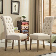 two gray chairs sitting next to each other in a living room