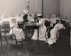 an old black and white photo of women in hospital wardes with children on cots