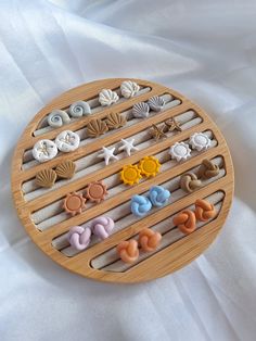 there is a wooden tray that has different types of buttons and seashells on it