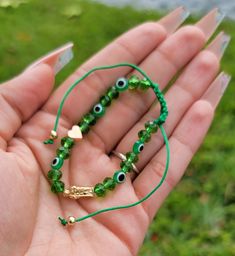 This bracelet has a very simple yet unique design. Fits both men and women and is adjustable to fit any size wrist! Green Cord Beautiful Golden Accents Clear green beads Adjustable Bracelets to fit any size wrist GREEN EVIL EYE MEANING: *Success with your dreams *Enjoyment and contentment *Good health