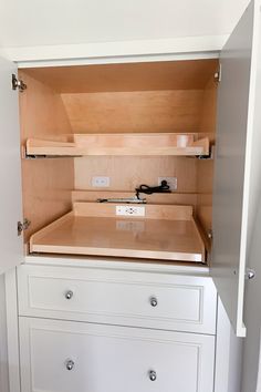 an empty white cabinet with drawers in it