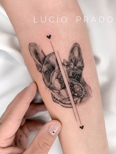 a woman's arm with two dogs on it and one is holding a pencil