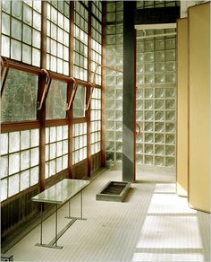 an empty room with glass blocks on the wall and windows in the floor, along with a book shelf